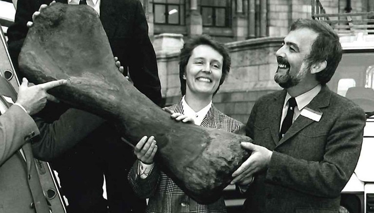 Woman and man holding a large bone and smiling 