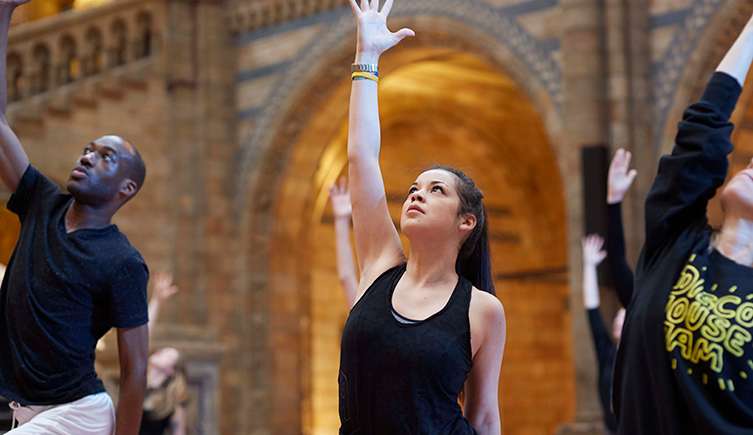 A photo of a woman doing yoga in the Museum's Hintze Hall